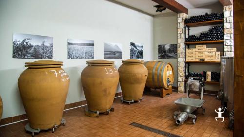 Zona di vinificazione con botti in una cantina a Benevento, dove coppie e gruppi degustano vini locali come Aglianico del Taburno e Falanghina.