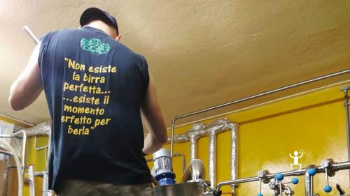 Produttore di birra artigianale a lavoro tra i tini di acciaio